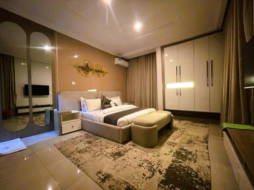 een slaapkamer met een groot bed en een groot tapijt bij Mikuch Apartments and Suites in Abuja