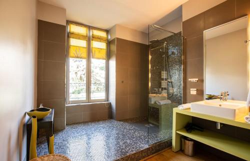 a bathroom with a sink and a shower at La Villa Fleury - La Nacre in Limoges