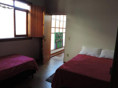 a room with two beds and a window at Pousada Melhor Hora in Cunha
