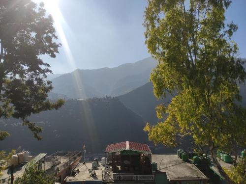 a view of a mountain range with the sun shining at Polet Mountain Resort in Mussoorie