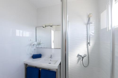 a white bathroom with a sink and a shower at Apartamentos Orly Club Arena Dorada in Puerto del Carmen