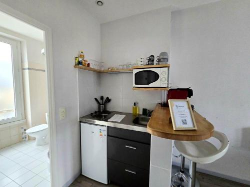 una piccola cucina con lavello e microonde di LAYTON - A 2 min de la plage, du sillon et d'Intra muros ! a Saint Malo