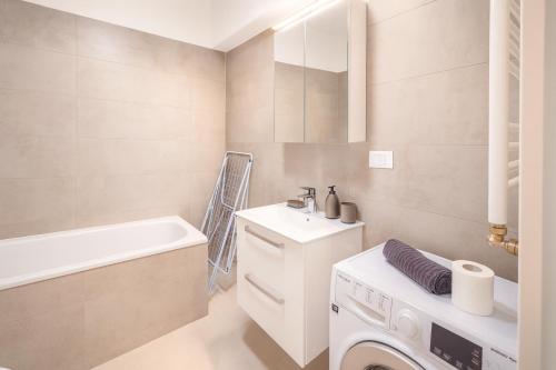 een badkamer met een wasmachine en een wastafel bij Smart Serendipity Apartments in Boekarest
