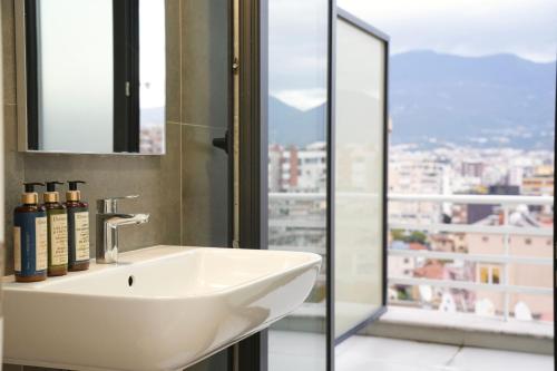 a white sink in a bathroom with a window at Rooftop Tirana in Tirana
