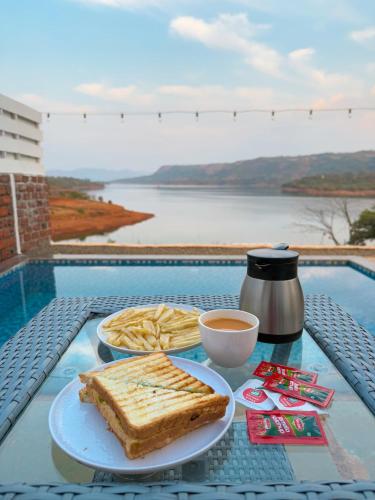 uma mesa com um prato de torradas e uma chávena de café em Waterrock Bhor em Pune