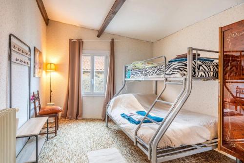a room with two bunk beds and a window at Gîte de l'ouvroux in Montournais