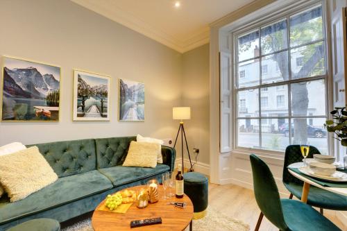 a living room with a green couch and a table at Portland Street Leamington Spa Apartments in Leamington Spa