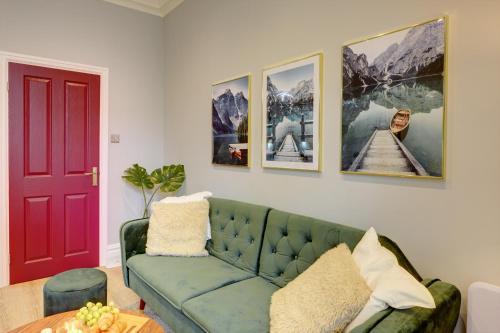 a living room with a green couch and a red door at Portland Street Leamington Spa Apartments in Leamington Spa