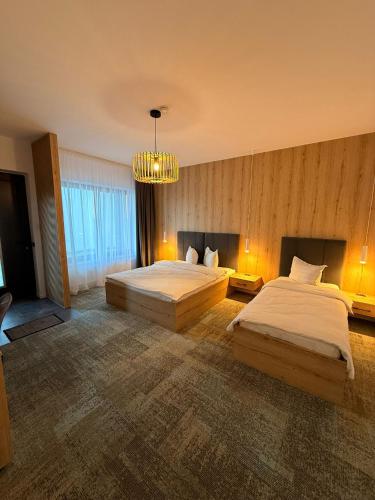 a large bedroom with two beds and a chandelier at Elegant House in Făgăraş
