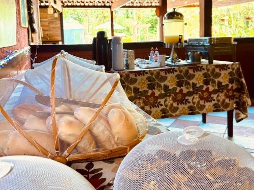 Praia do BananalにあるPousada Recanto dos Limaのテーブルの上にパンの入ったバスケットが置かれたテーブル