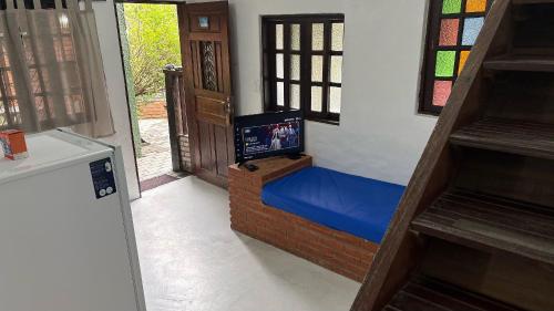 Habitación con cama y TV. en Lua Chalés 14 chalés equipados com churrasqueira individua , piscina e hidro incluindo café da manhã servido no quarto , roupa de cama, toalhas de banho e de praia a apenas 600 metros da praia de Maresias, en Maresias