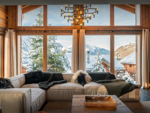 a living room with a couch and a large window at Chalet Fango - OVO Network in Saint-Martin-de-Belleville