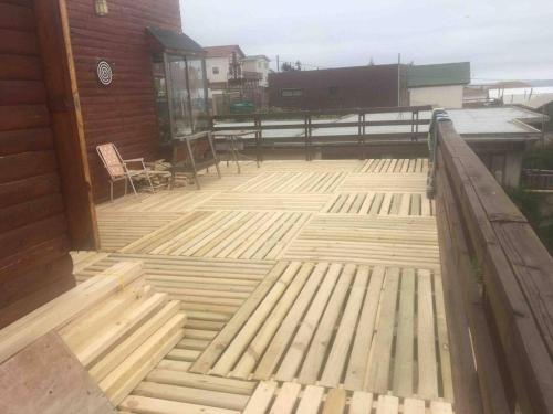 eine Holzterrasse mit Zaun und Stühlen an einem Haus in der Unterkunft Cabaña Las Cruces in Las Cruces