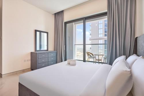a bedroom with a white bed and a large window at STAY BY LATINEM Luxury 1BR Holiday Home CVG 1803 near Burj Khalifa in Dubai