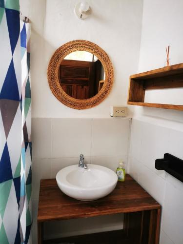 a bathroom with a sink and a mirror at Las Cabañas de la Iguana in Ayampe