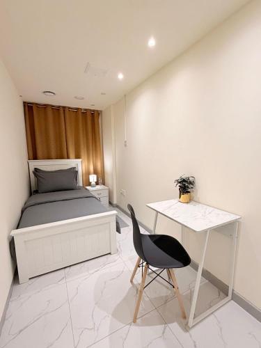 a bedroom with a bed and a desk and a chair at PrimeLuxe Stay by Lavishhub in Abu Dhabi