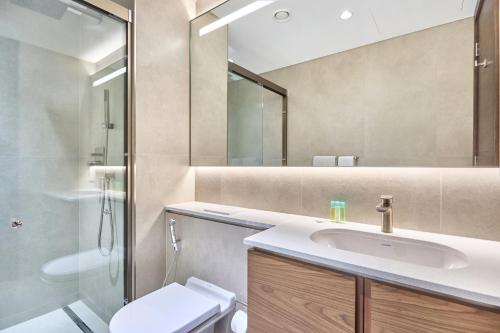 a bathroom with a sink and a toilet and a mirror at STAY BY LATINEM Luxury 1BR Holiday Home CVG 1803 near Burj Khalifa in Dubai