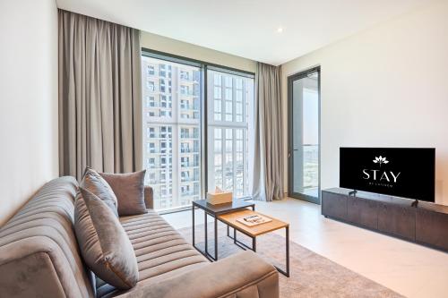 a living room with a couch and a tv at STAY BY LATINEM Luxury 1BR Holiday Home CVG 1803 near Burj Khalifa in Dubai