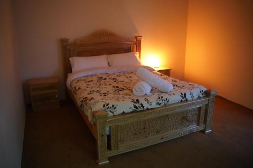 Un dormitorio con una cama con cabecero de madera. en Secret Garden Hostel & Guesthouse, en Chitral