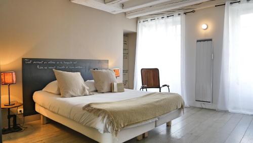 Un dormitorio con una cama grande con una pizarra en la pared. en La Nuit - Suite avec baignoire, en Nantes