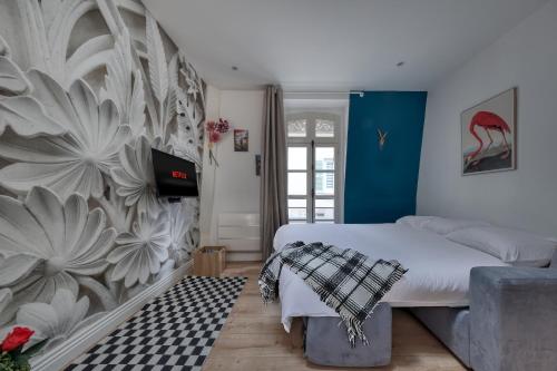 Le Secret d'Alice Centre ville Balcon في لاني: غرفة نوم بسرير وجدار مع جدارية ورد