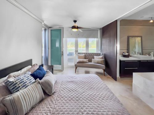 1 dormitorio con cama, sofá y baño en Villa Capitán Modern Stay Near Beach with pool, en Vega Alta