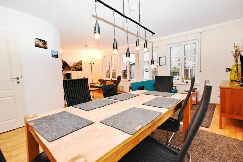 Un comedor con mesa y sillas de madera. en Kranichdüne, en Hohwacht