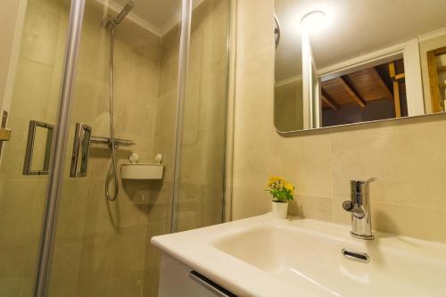 ein Badezimmer mit Waschbecken und Dusche in der Unterkunft CASAS DA RUA NOVA in Alijó