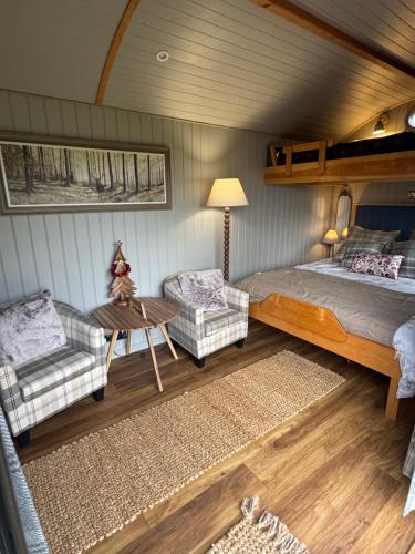 Acorn Hideaway في كانتربيري: غرفة نوم بها سرير وكرسيين وطاولة