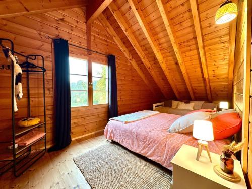 a bedroom with a bed in a log cabin at Au Chalet d'Aurélie in Chagny