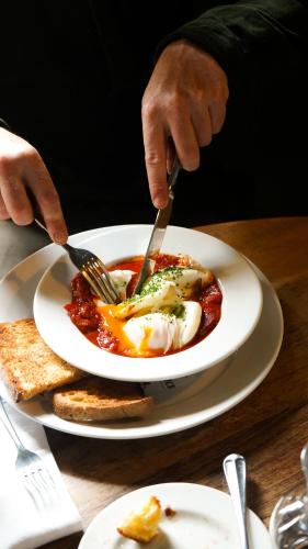 una persona comiendo un plato de comida con un tenedor y un cuchillo en The Pembroke Arms, en Salisbury