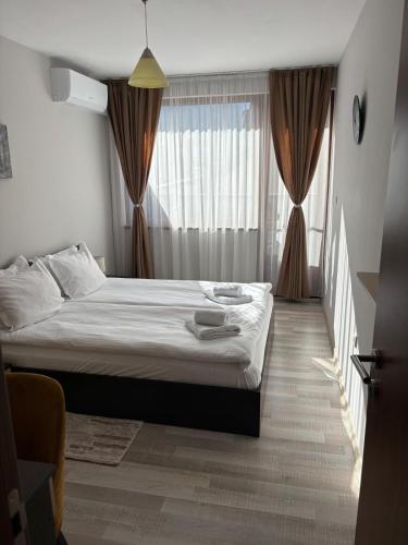 a bedroom with a bed and a large window at Апартамент Рафаела-Мартина-Регнум in Bansko