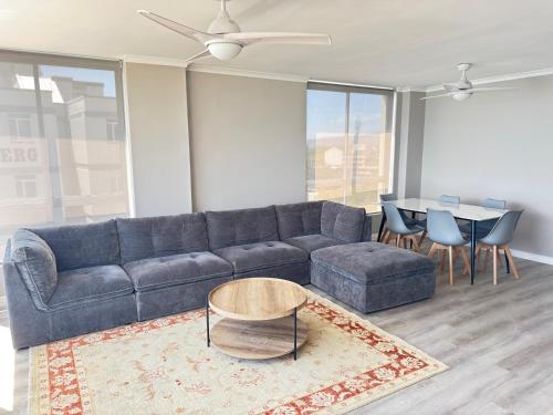 un soggiorno con un divano blu e un tavolo di Odeon Ocean View a Strand
