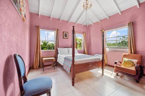 Serenity Villa - 3bd by ZenBreak في سانت بيتير: غرفة نوم بجدران وردية وسرير ونوافذ