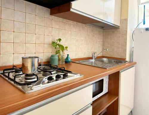 een keuken met een fornuis en een spoelbak bij Holihome Vascello A7 in Tortoreto Lido