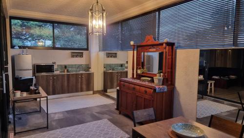 Habitación con cocina con espejo y mesa. en Stay at 64 Omeya, en Windhoek