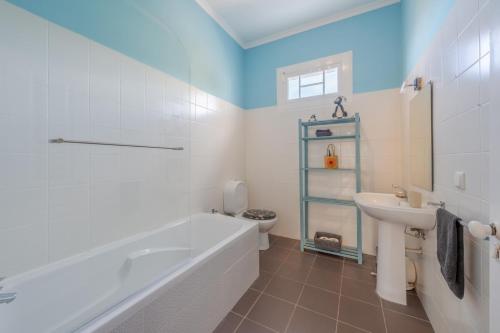 a bathroom with a tub and a sink and a toilet at Flora Garden House by HR Madeira in Estreito da Calheta