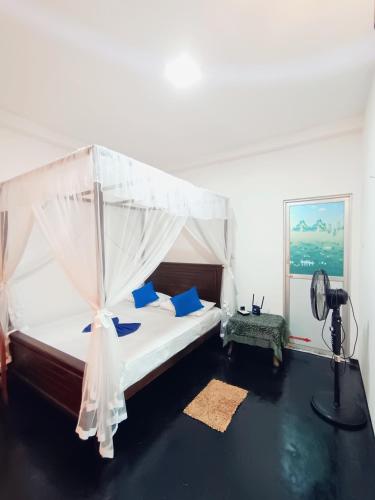 a bedroom with a bed with a canopy at Villa lovely birds mirissa in Mirissa