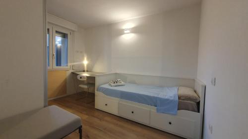 a small white bedroom with a bed and a sink at Ultimo piano con terrazzo e posto auto in Zola Predosa
