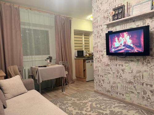 Tiny Paradise self check-in في نارفا: غرفة معيشة مع تلفزيون على الحائط