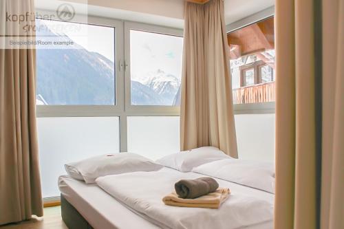 una cama en una habitación con una ventana grande en Alpenperle, en Ischgl