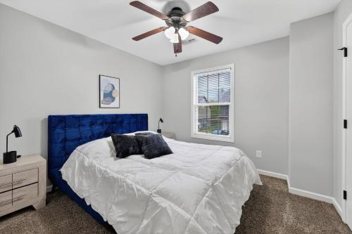 a bedroom with a blue bed with a ceiling fan at Inviting 2BR hideaway with contemporary touches in Clarksville
