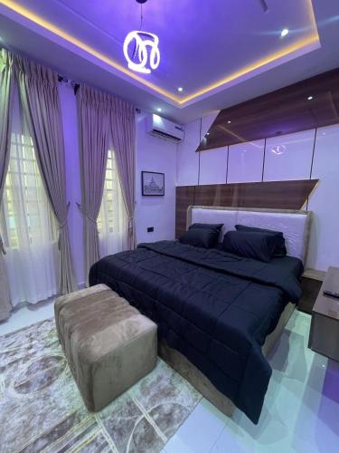 a bedroom with a large bed and a couch at Tee Motley shortlet in Ejigbo