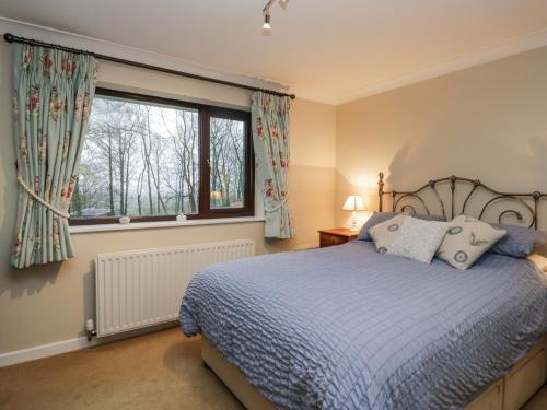 ein Schlafzimmer mit einem Bett und einem Fenster in der Unterkunft Beech Brae in Kendal