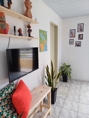 een woonkamer met een flatscreen-tv aan de muur bij Suite Africana Aracaju in Aracaju