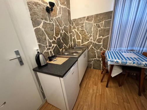 Una pequeña cocina con encimera, mesa y estufa. en Landhotel Waldschänke, en Berlín