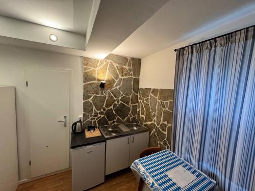 a kitchen with a counter and a sink in a room at Landhotel Waldschänke in Berlin