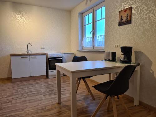 una cucina con un tavolo e sedie in una stanza di Apartment Drachennest mit Kochnische & Bad a Swisttal