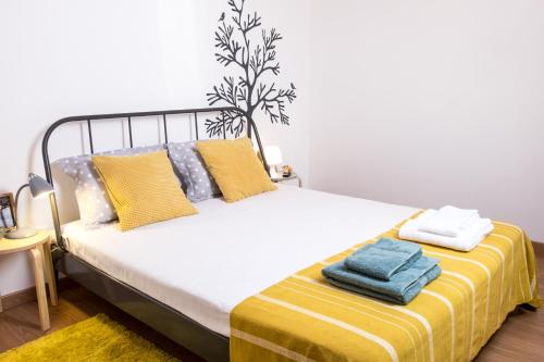 a bedroom with a bed with yellow and blue towels on it at Our Friends Apartment in Lisbon