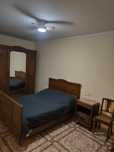 a bedroom with a bed and a mirror and a chair at CASA EL LAUREL in Vélez-Rubio